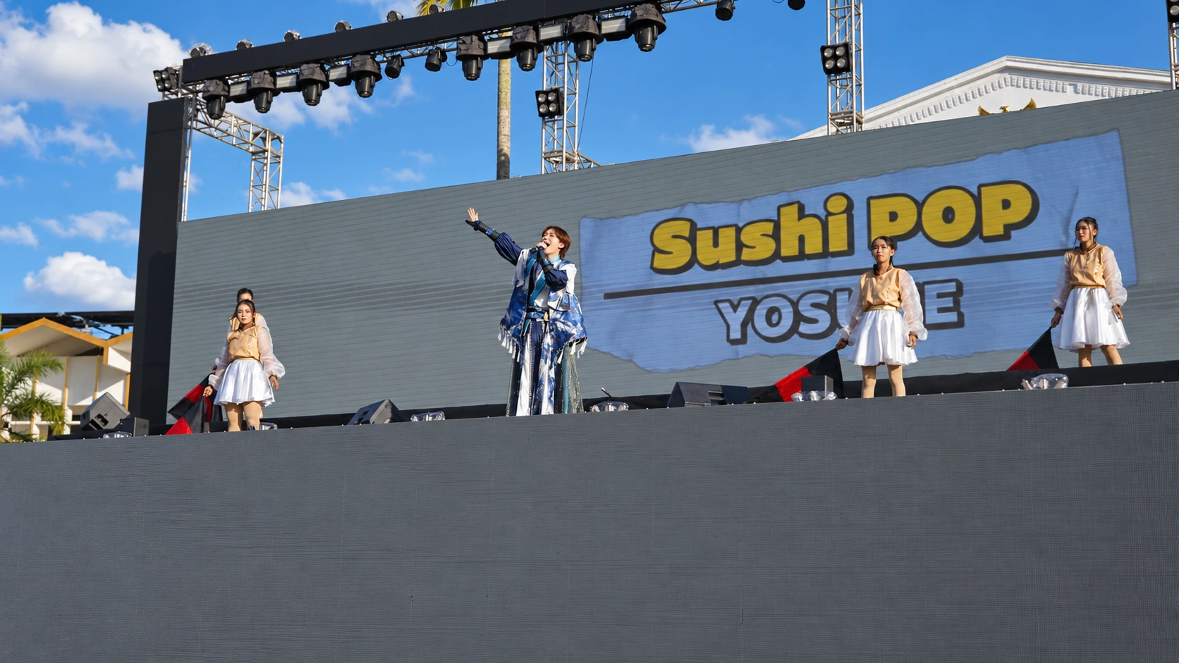 ダンサーとともに、インドネシアのステージで手を上げて歌うYOSUKE